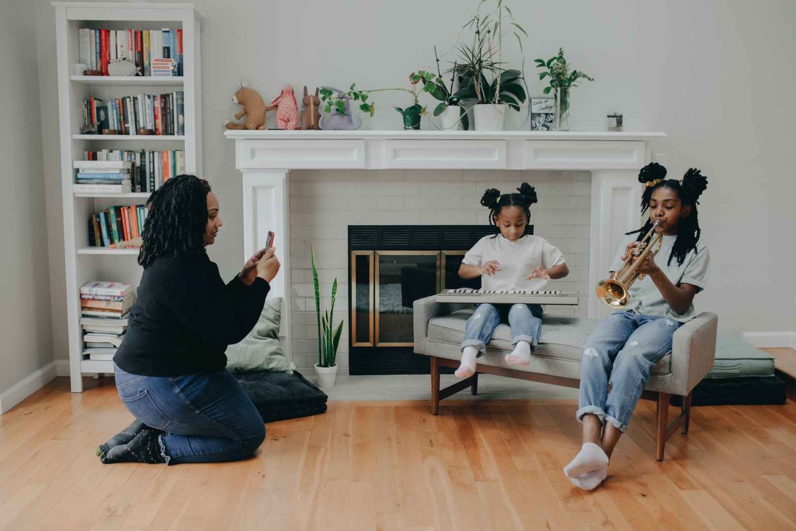 a mother taking photos of her kids while playing musical instruments